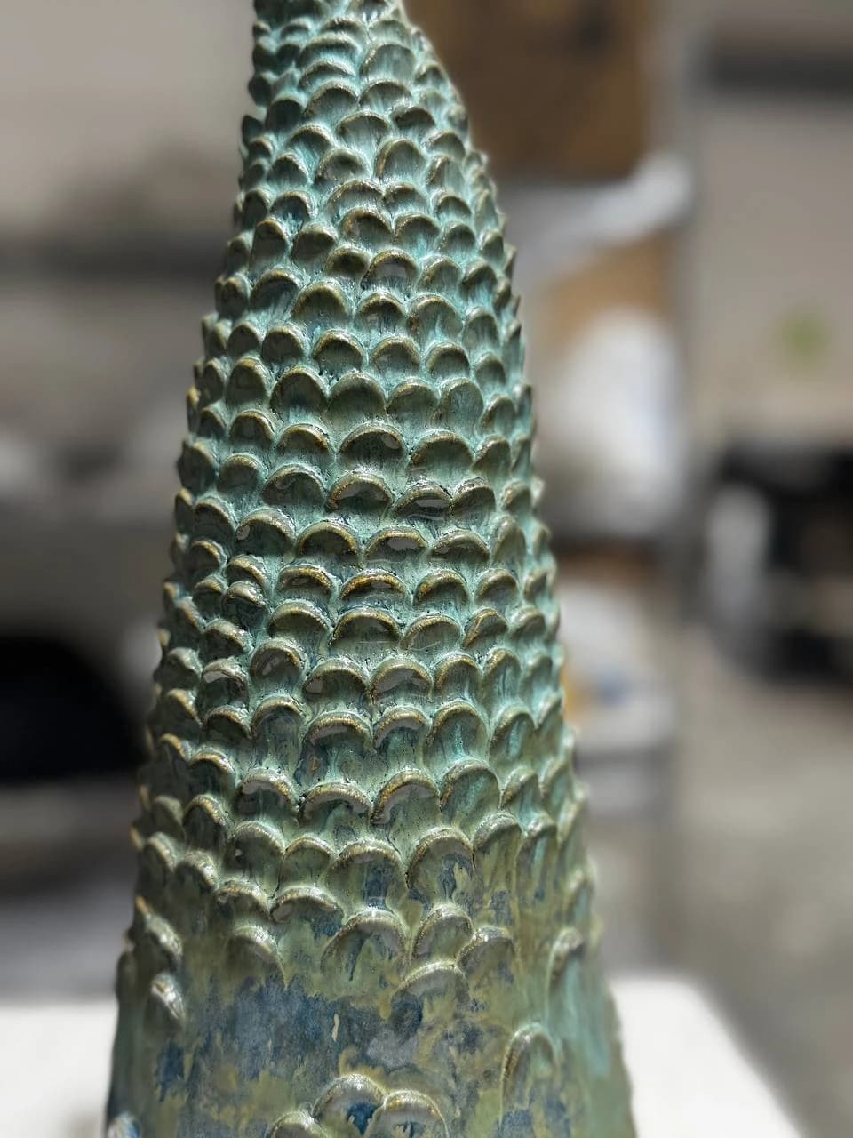 Individually shaped repeating forms across the glazed cypress surface.