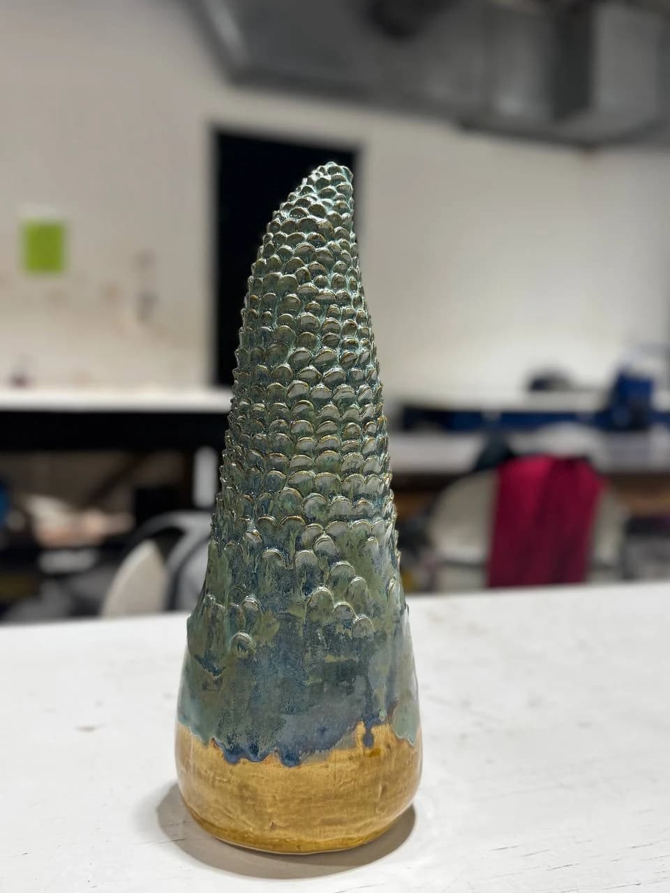 Finished ceramic cypress with a green-blue textured surface and ochre base.