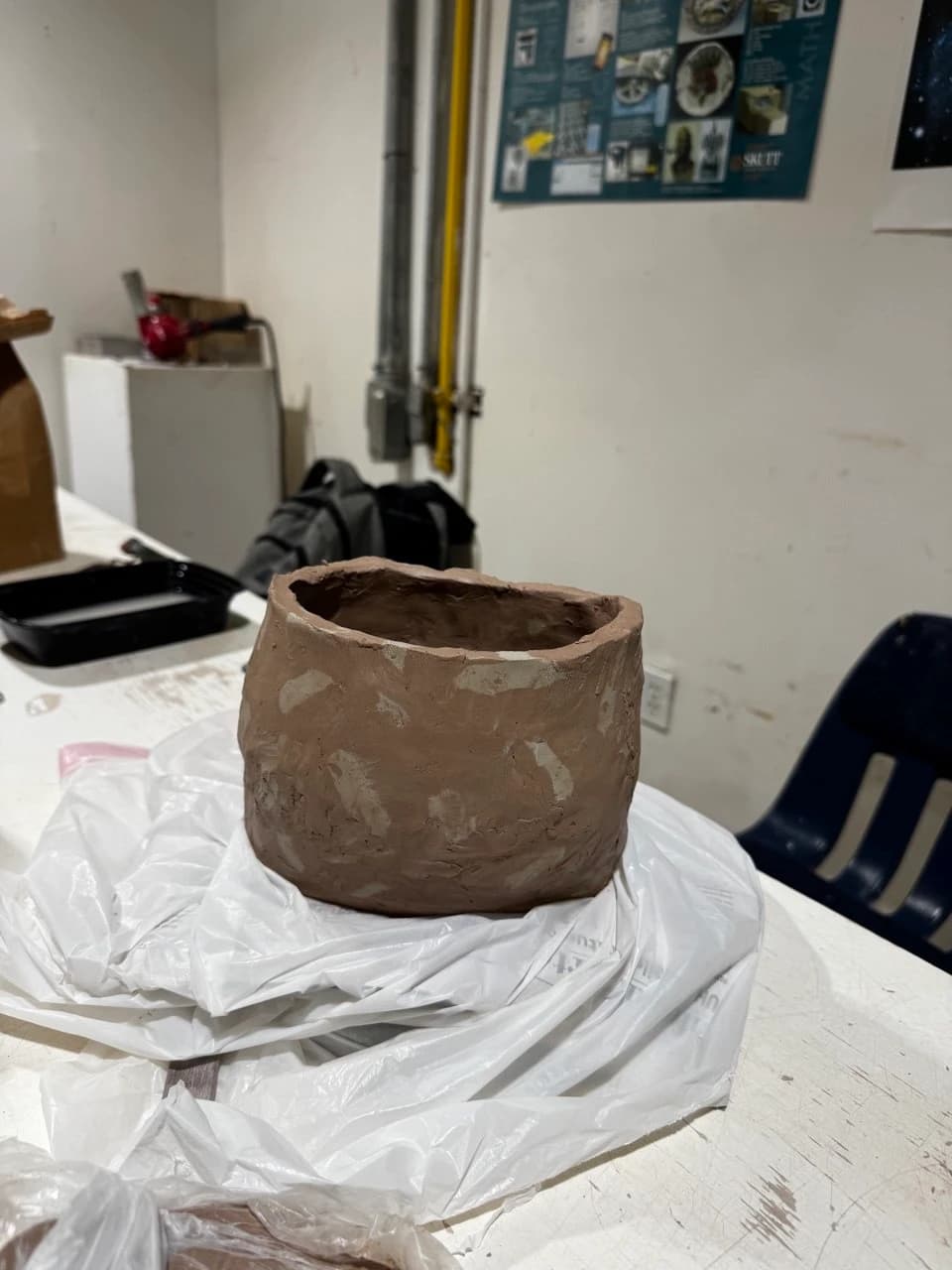 Brown vessel during the making process, before the finished glazed stage.